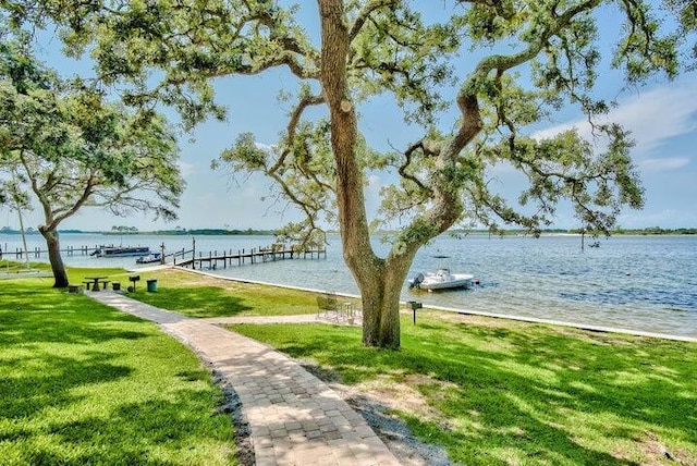 209 W Miracle Strip Pkwy Unit H 103, Mary Esther, FL 32569 - dock area featuring a lawn and a water view