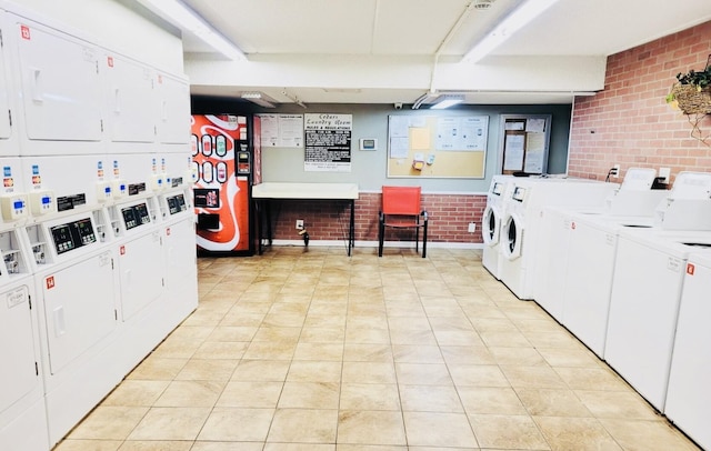 209 W Miracle Strip Pkwy Unit H 103, Mary Esther, FL 32569 - community laundry room with estacked washer and dryer, brick wall, washer and clothes dryer, and light tile patterned flooring