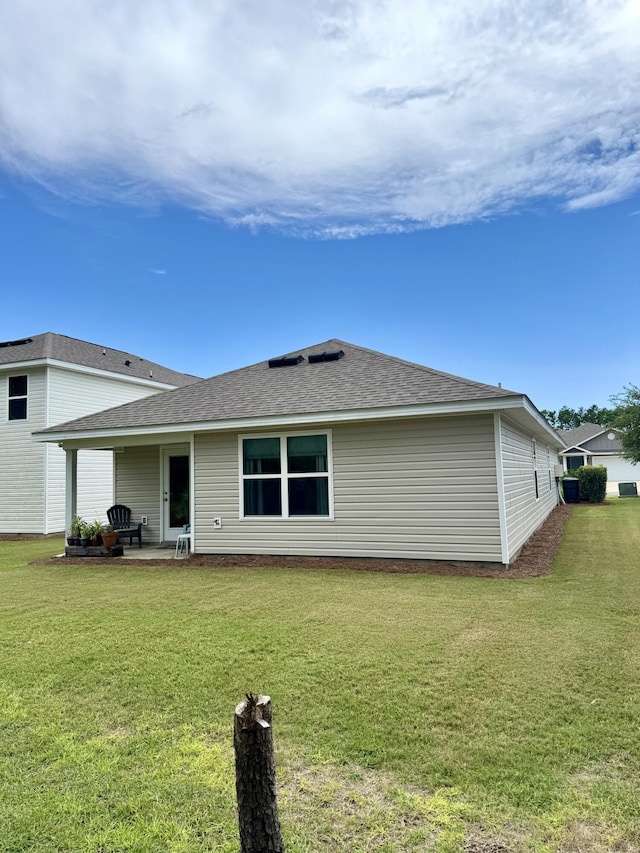 629 Earl Godwin Rd, Freeport, FL 32439 - rear view of property with a patio, a yard, and a shingled roof