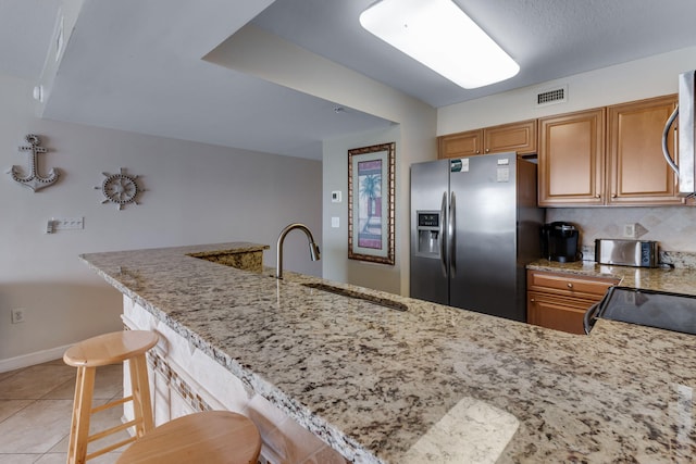 866 Santa Rosa Blvd Unit 302, Fort Walton Beach, FL 32548 - kitchen with stainless steel appliances, a kitchen bar, light stone counters, and light tile patterned floors