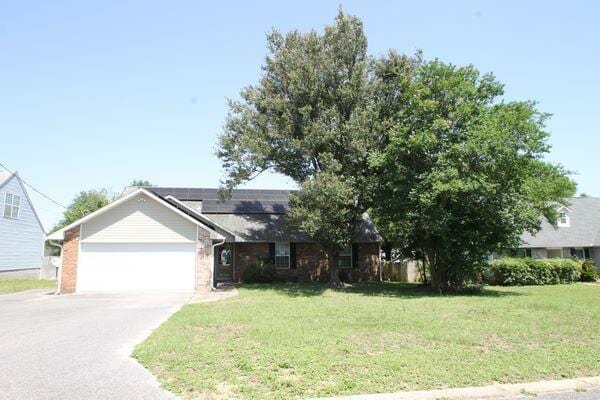 116 Nicole Ln, Crestview, FL 32539 - ranch-style house featuring roof mounted solar panels, a front yard, an attached garage, concrete driveway, and brick siding