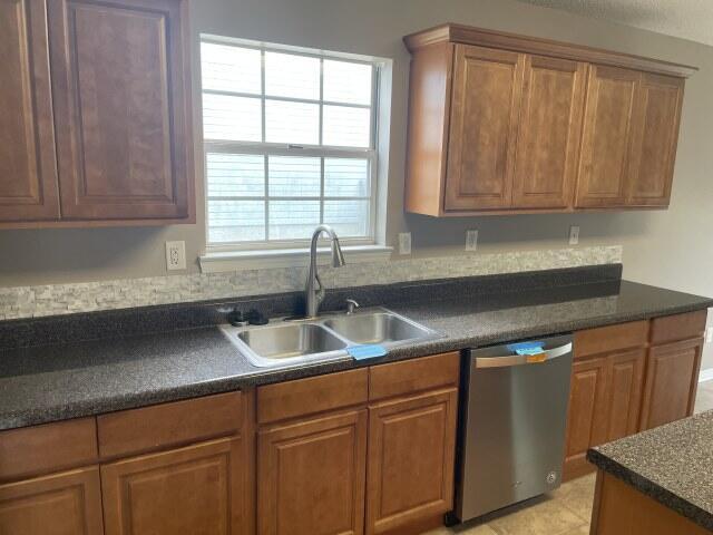 116 Nicole Ln, Crestview, FL 32539 - kitchen featuring dishwasher, dark countertops, and brown cabinets