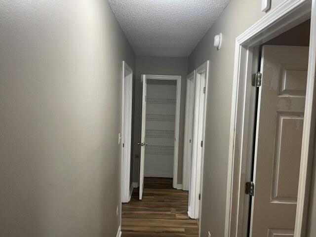 116 Nicole Ln, Crestview, FL 32539 - corridor with dark wood-style flooring and a textured ceiling