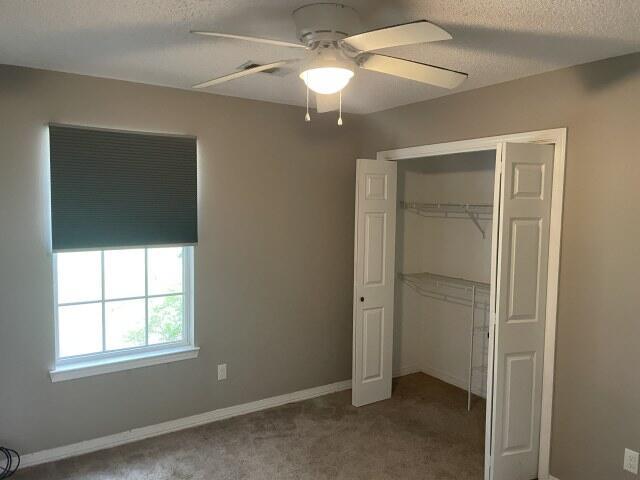116 Nicole Ln, Crestview, FL 32539 - unfurnished bedroom with a textured ceiling, carpet flooring, a closet, and a ceiling fan