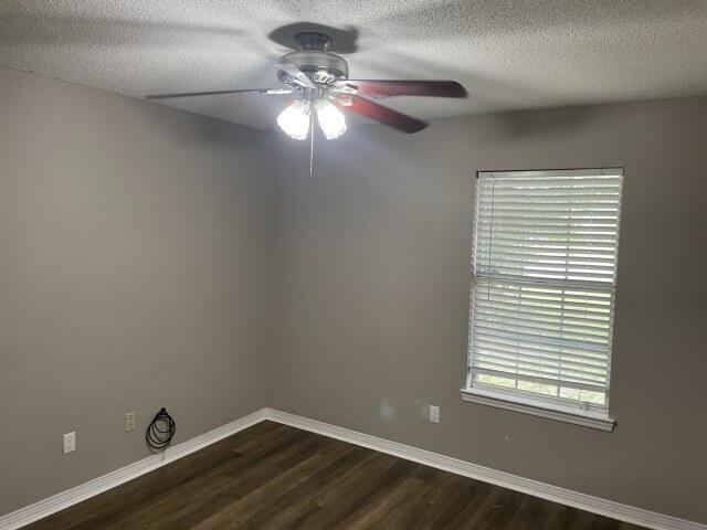 116 Nicole Ln, Crestview, FL 32539 - empty room with ceiling fan, dark wood-type flooring, and a textured ceiling