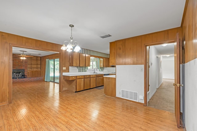 19 Bayview Dr, Shalimar, FL 32579 - kitchen featuring wooden walls, brown cabinetry, a ceiling fan, light countertops, and light wood finished floors