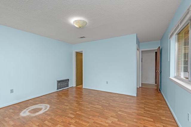 19 Bayview Dr, Shalimar, FL 32579 - empty room featuring light wood-style flooring, a textured ceiling, and heating unit