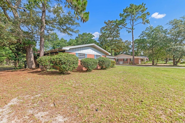 19 Bayview Dr, Shalimar, FL 32579 - view of front of home with board and batten siding, brick siding, and a front yard