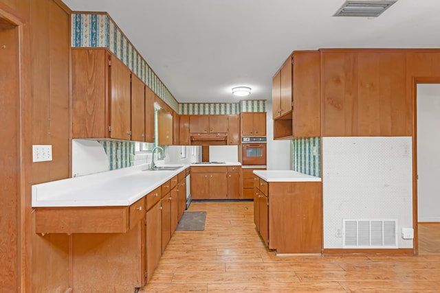 19 Bayview Dr, Shalimar, FL 32579 - kitchen with wall oven, light wood-style flooring, brown cabinets, light countertops, and wallpapered walls