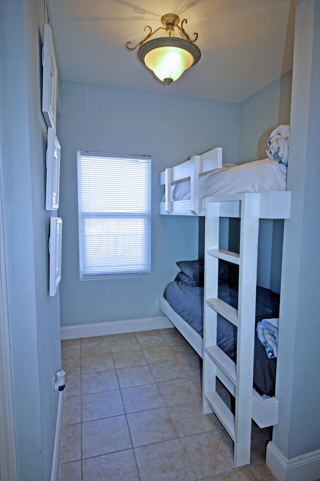 9902 S Thomas Dr Unit 1828, Panama City Beach, FL 32408 - bedroom with baseboards and light tile patterned floors