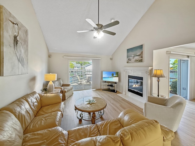458 Linkside Pl, Miramar Beach, FL 32550 - living area with ceiling fan, wood finished floors, high vaulted ceiling, a glass covered fireplace, and healthy amount of natural light
