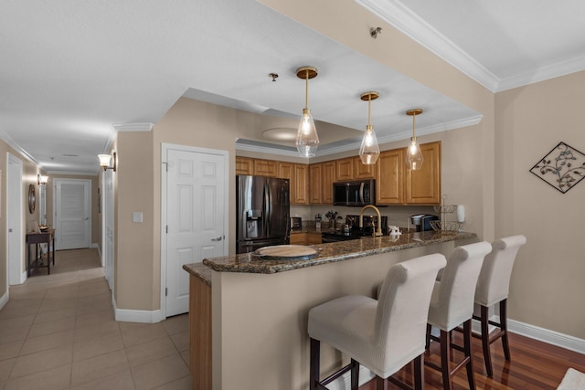112 Seascape Dr Unit 1201, Miramar Beach, FL 32550 - kitchen with refrigerator with ice dispenser, stainless steel microwave, a peninsula, baseboards, and dark stone counters