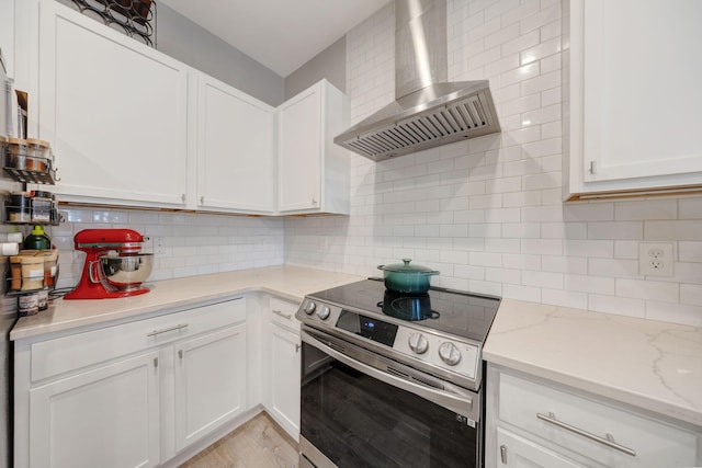 233 Sand Oak Blvd, Panama City Beach, FL 32413 - kitchen with wall chimney exhaust hood, electric stove, decorative backsplash, and white cabinetry