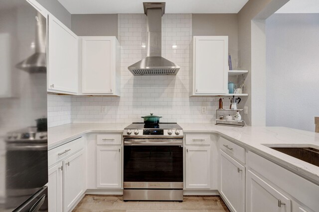 233 Sand Oak Blvd, Panama City Beach, FL 32413 - kitchen featuring stainless steel appliances, wall chimney range hood, tasteful backsplash, and white cabinets