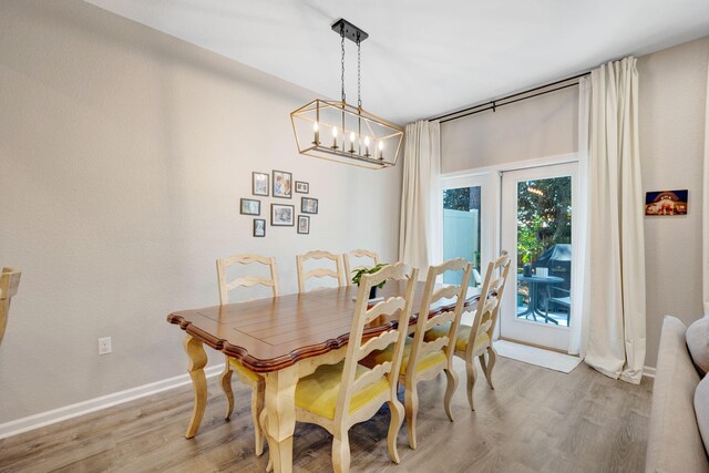 233 Sand Oak Blvd, Panama City Beach, FL 32413 - dining space featuring light wood finished floors, a chandelier, and baseboards