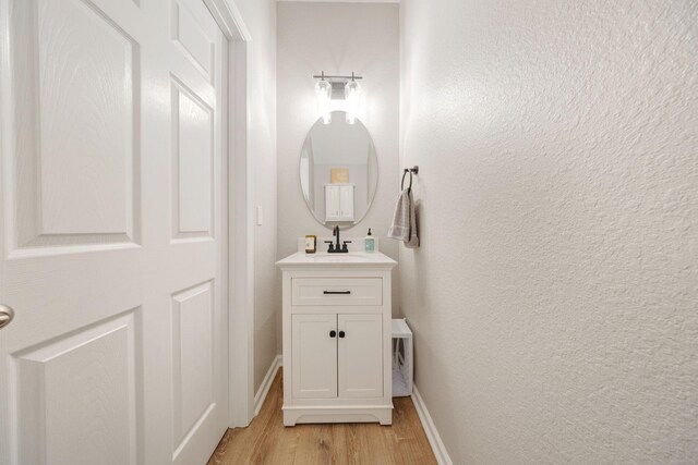233 Sand Oak Blvd, Panama City Beach, FL 32413 - bathroom featuring wood finished floors, vanity, and baseboards