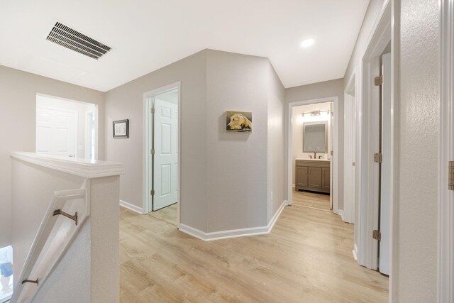 233 Sand Oak Blvd, Panama City Beach, FL 32413 - corridor featuring light wood finished floors, baseboards, and a sink
