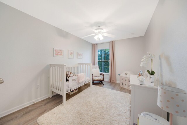 233 Sand Oak Blvd, Panama City Beach, FL 32413 - bedroom with a crib, wood finished floors, baseboards, and a ceiling fan