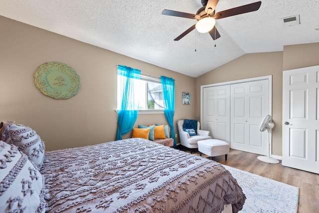 6922 Sea Turtle Cir, Navarre, FL 32566 - bedroom featuring a closet, a textured ceiling, wood finished floors, vaulted ceiling, and a ceiling fan