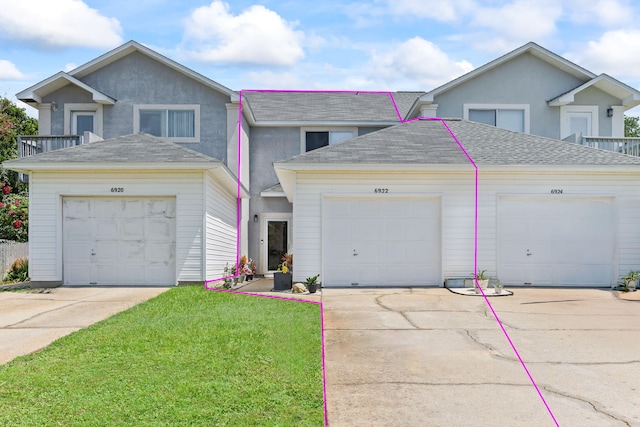 6922 Sea Turtle Cir, Navarre, FL 32566 - view of front of house featuring a shingled roof, a front yard, driveway, and stucco siding