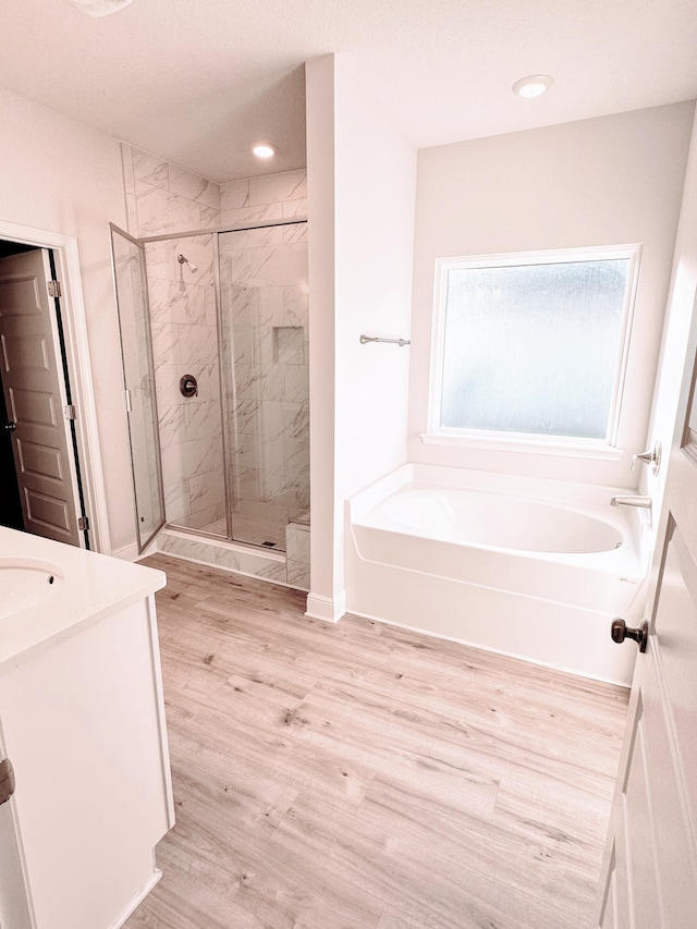 56 Secluded Cir, Freeport, FL 32439 - bathroom with a garden tub, a marble finish shower, vanity, wood finished floors, and recessed lighting