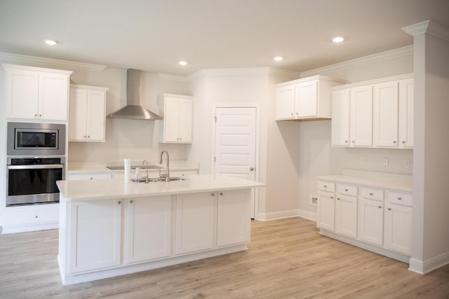 56 Secluded Cir, Freeport, FL 32439 - kitchen with appliances with stainless steel finishes, wall chimney range hood, white cabinetry, a kitchen island with sink, and light countertops