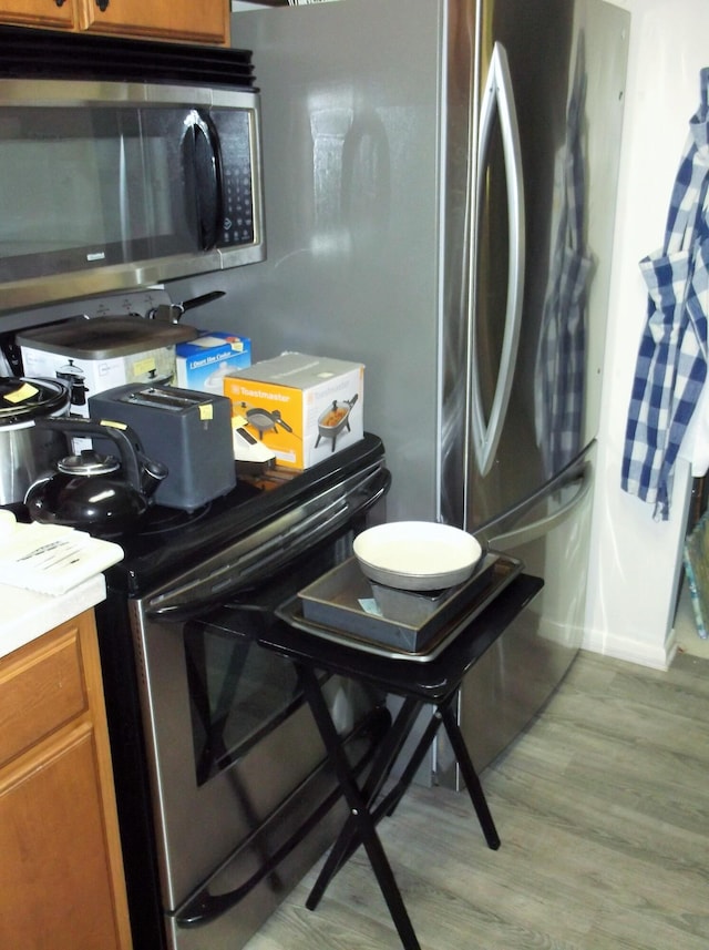 8 NE Carlyle Ct, Fort Walton Beach, FL 32547 - kitchen view of stainless steel appliances, brown cabinets, light wood finished floors, and light countertops