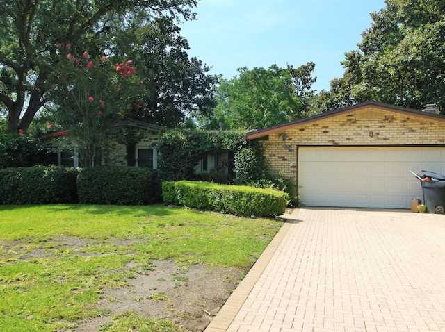 8 NE Carlyle Ct, Fort Walton Beach, FL 32547 - obstructed view of property featuring a front lawn, brick siding, a garage, and driveway