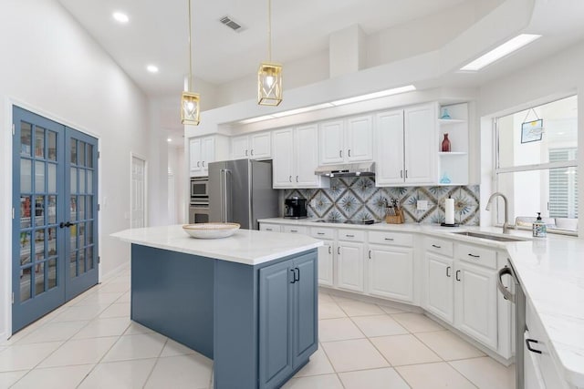 527 Indigo Loop, Miramar Beach, FL 32550 - kitchen with stainless steel appliances, under cabinet range hood, a sink, backsplash, and white cabinets