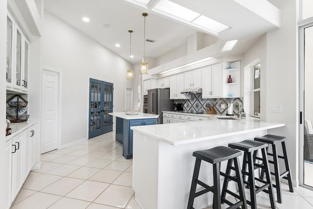 527 Indigo Loop, Miramar Beach, FL 32550 - kitchen with freestanding refrigerator, under cabinet range hood, backsplash, a kitchen island, and white cabinets
