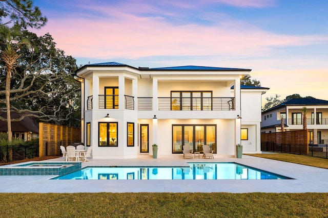 253 Driftwood Point Rd, Santa Rosa Beach, FL 32459 - back of house with a balcony, stucco siding, a patio, and a pool with connected hot tub