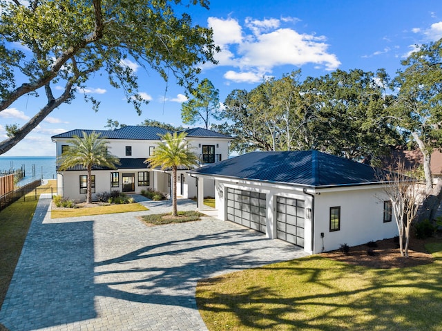 253 Driftwood Point Rd, Santa Rosa Beach, FL 32459 - view of front of house featuring stucco siding, driveway, an attached garage, metal roof, and a water view