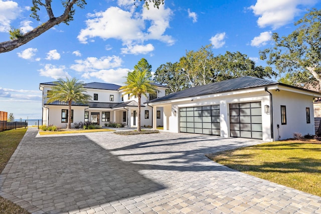 253 Driftwood Point Rd, Santa Rosa Beach, FL 32459 - view of front of property featuring decorative driveway, a garage, stucco siding, and metal roof