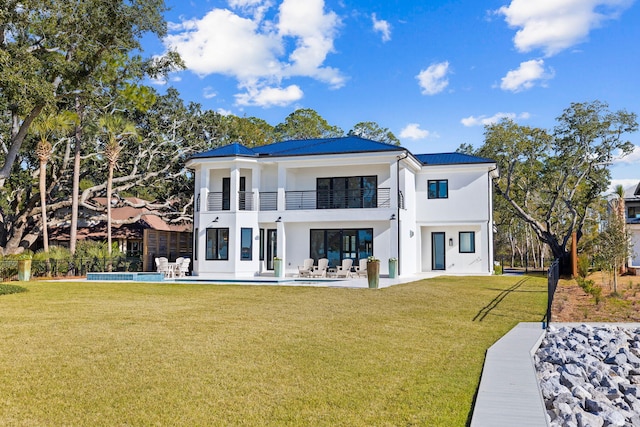 253 Driftwood Point Rd, Santa Rosa Beach, FL 32459 - rear view of property with a balcony, stucco siding, a patio area, a yard, and metal roof