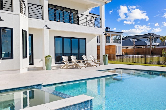 253 Driftwood Point Rd, Santa Rosa Beach, FL 32459 - rear view of property featuring a balcony, a patio, a pool with connected hot tub, and stucco siding