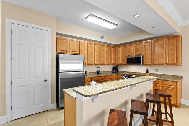 1653 W County Highway 30a Unit 1119, Santa Rosa Beach, FL 32459 - kitchen featuring appliances with stainless steel finishes, light tile patterned floors, light stone counters, a kitchen breakfast bar, and recessed lighting