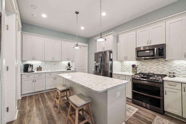 38 Constant Ave, Santa Rosa Beach, FL 32459 - kitchen featuring stainless steel appliances, decorative backsplash, dark wood finished floors, a breakfast bar area, and light countertops
