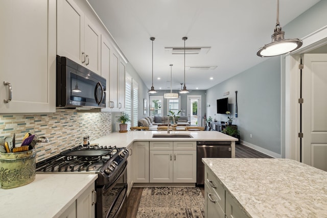 38 Constant Ave, Santa Rosa Beach, FL 32459 - kitchen with appliances with stainless steel finishes, open floor plan, a peninsula, tasteful backsplash, and hanging light fixtures