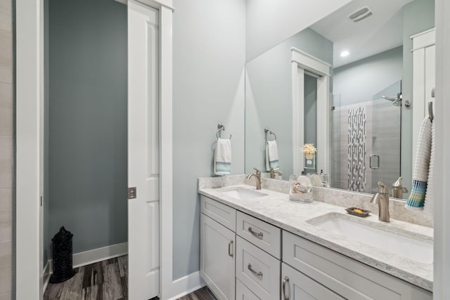 38 Constant Ave, Santa Rosa Beach, FL 32459 - full bathroom with double vanity, a stall shower, wood finished floors, and baseboards