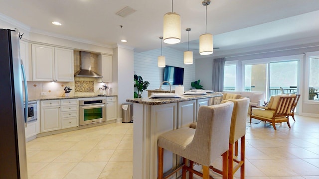 11807 Front Beach Rd Unit 1- 2204, Panama City Beach, FL 32407 - kitchen featuring wall chimney range hood, stainless steel appliances, decorative backsplash, light tile patterned floors, and crown molding