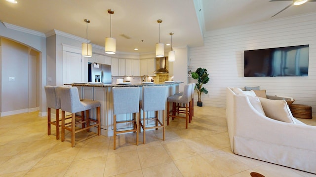 11807 Front Beach Rd Unit 1- 2204, Panama City Beach, FL 32407 - kitchen featuring stainless steel fridge with ice dispenser, open floor plan, wall chimney range hood, ornamental molding, and a kitchen bar
