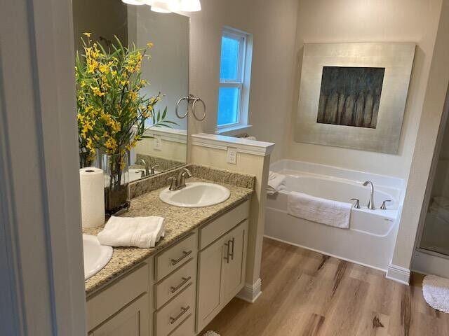 115 S Speckled Trout Ln Lot 262, Freeport, FL 32439 - bathroom featuring a bath, wood finished floors, and double vanity