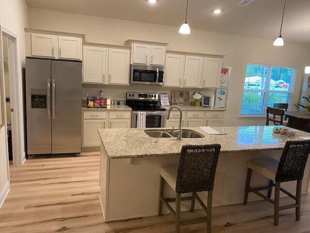 115 S Speckled Trout Ln Lot 262, Freeport, FL 32439 - kitchen with stainless steel appliances, light wood-style floors, white cabinetry, pendant lighting, and recessed lighting