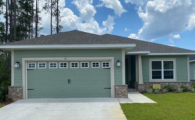 115 S Speckled Trout Ln Lot 262, Freeport, FL 32439 - view of front facade featuring an attached garage, driveway, brick siding, and a front yard