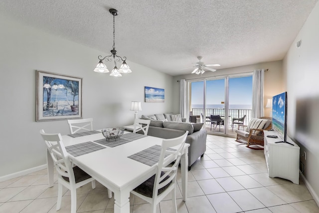 1200 Scenic Gulf Dr Unit B412, Miramar Beach, FL 32550 - dining area with a ceiling fan, a textured ceiling, light tile patterned floors, and a chandelier