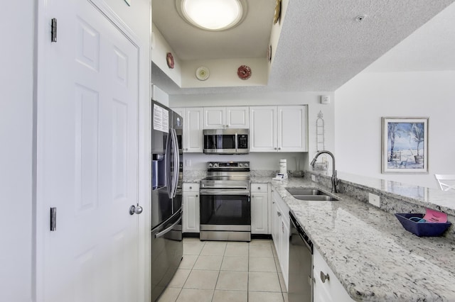 1200 Scenic Gulf Dr Unit B412, Miramar Beach, FL 32550 - kitchen with appliances with stainless steel finishes, a sink, light tile patterned floors, and white cabinetry