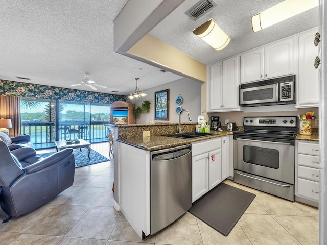 85 S Driftwood Bay Unit 227, Miramar Beach, FL 32550 - kitchen with stainless steel appliances, open floor plan, a textured ceiling, a sink, and a peninsula