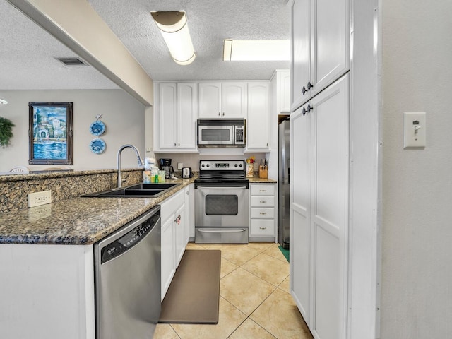 85 S Driftwood Bay Unit 227, Miramar Beach, FL 32550 - kitchen with appliances with stainless steel finishes, a sink, a peninsula, white cabinetry, and a textured ceiling