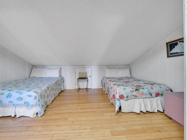 85 S Driftwood Bay Unit 227, Miramar Beach, FL 32550 - bedroom featuring wood finished floors, a textured ceiling, and lofted ceiling