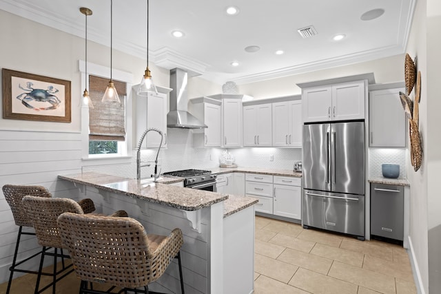14 The Heron Cv, Inlet Beach, FL 32461 - kitchen featuring stainless steel appliances, wall chimney exhaust hood, a peninsula, crown molding, and light stone counters